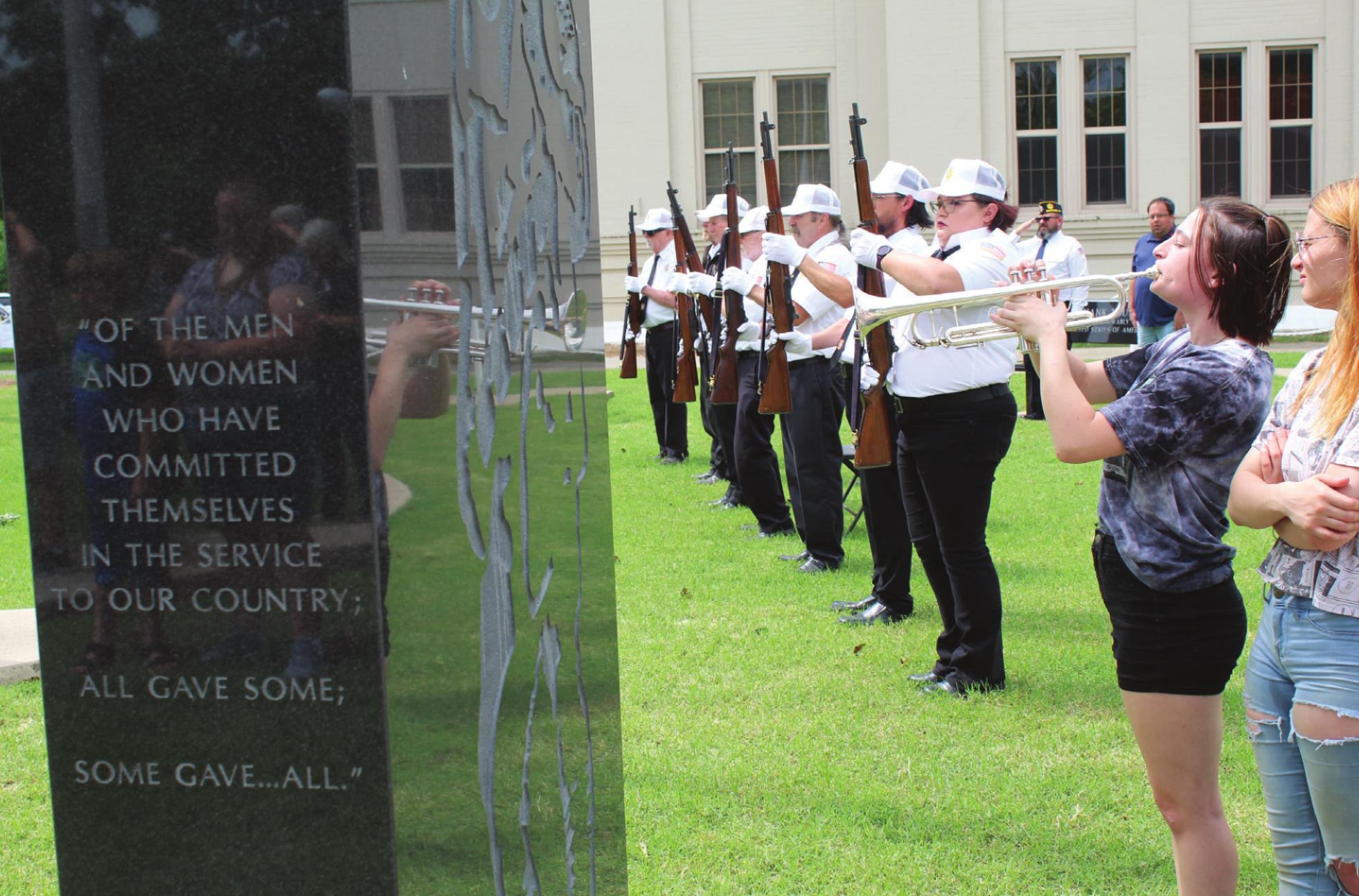 The VFW Post 1317 Honor Guard stands at attention, as OBU student Hannah McMurtrey plays "Taps."
