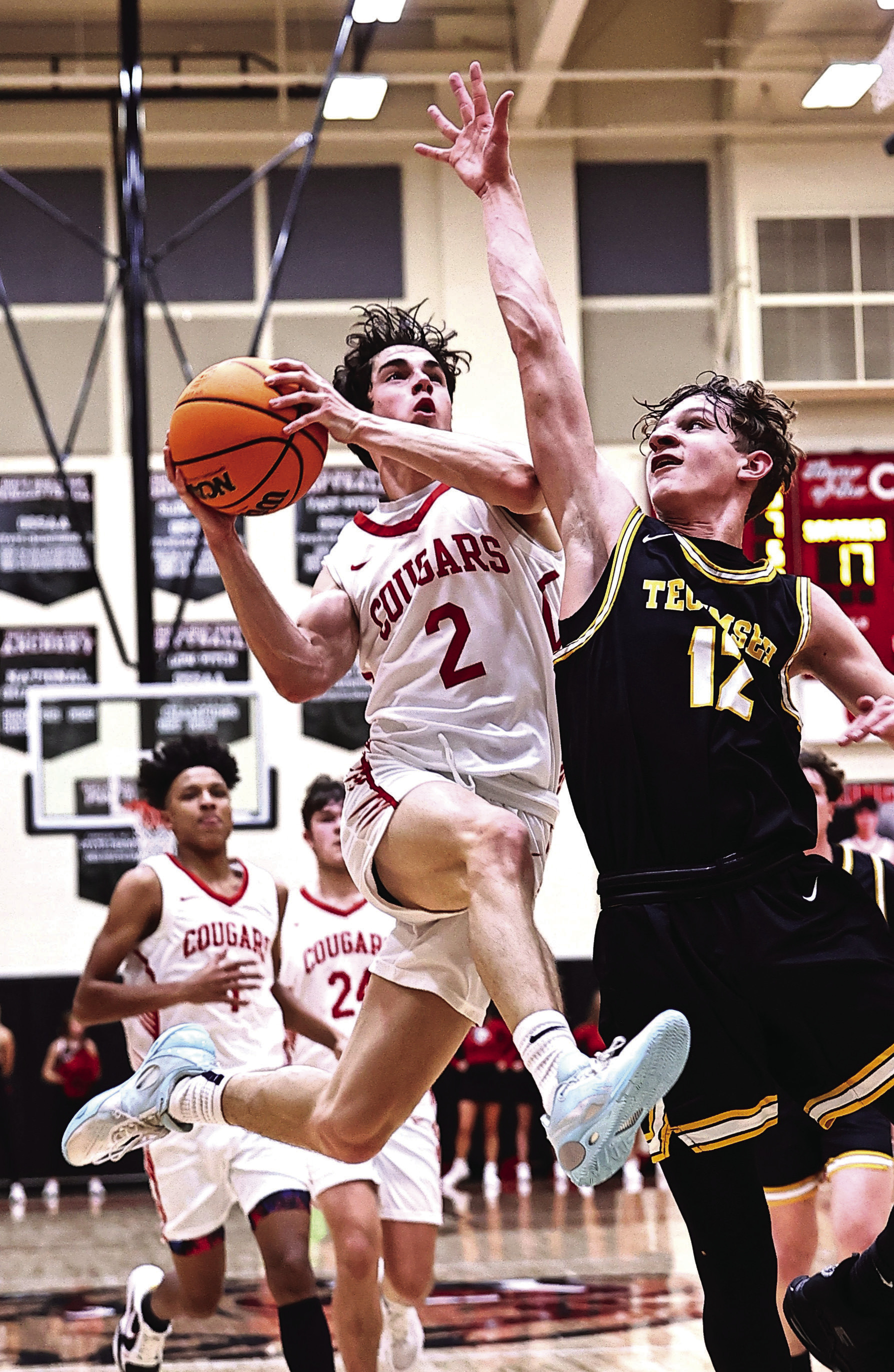 Tecumseh’s Kohen Warden tries to block the shot as North Rock Creek’s David King leaps to the basket. Photo courtesy of Gowin Photography