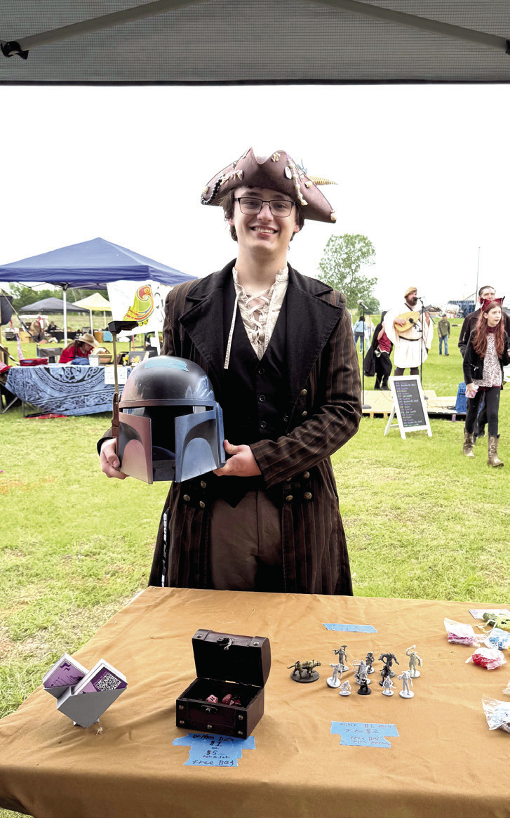 Pictured right, Shawnee's Lane Cowan poses with a helmet he made and sold at the Fifth Annual Secret Garden Medieval and Fantasy Faire held behind Shawnee Mall on April 25-26. Cowan says he will gladly participate again next time and bring more inventory, as he almost sold out. All booth owners were required to dress up for the event that brought out quite a crowd. Julie Talton, Countywide &amp; Sun