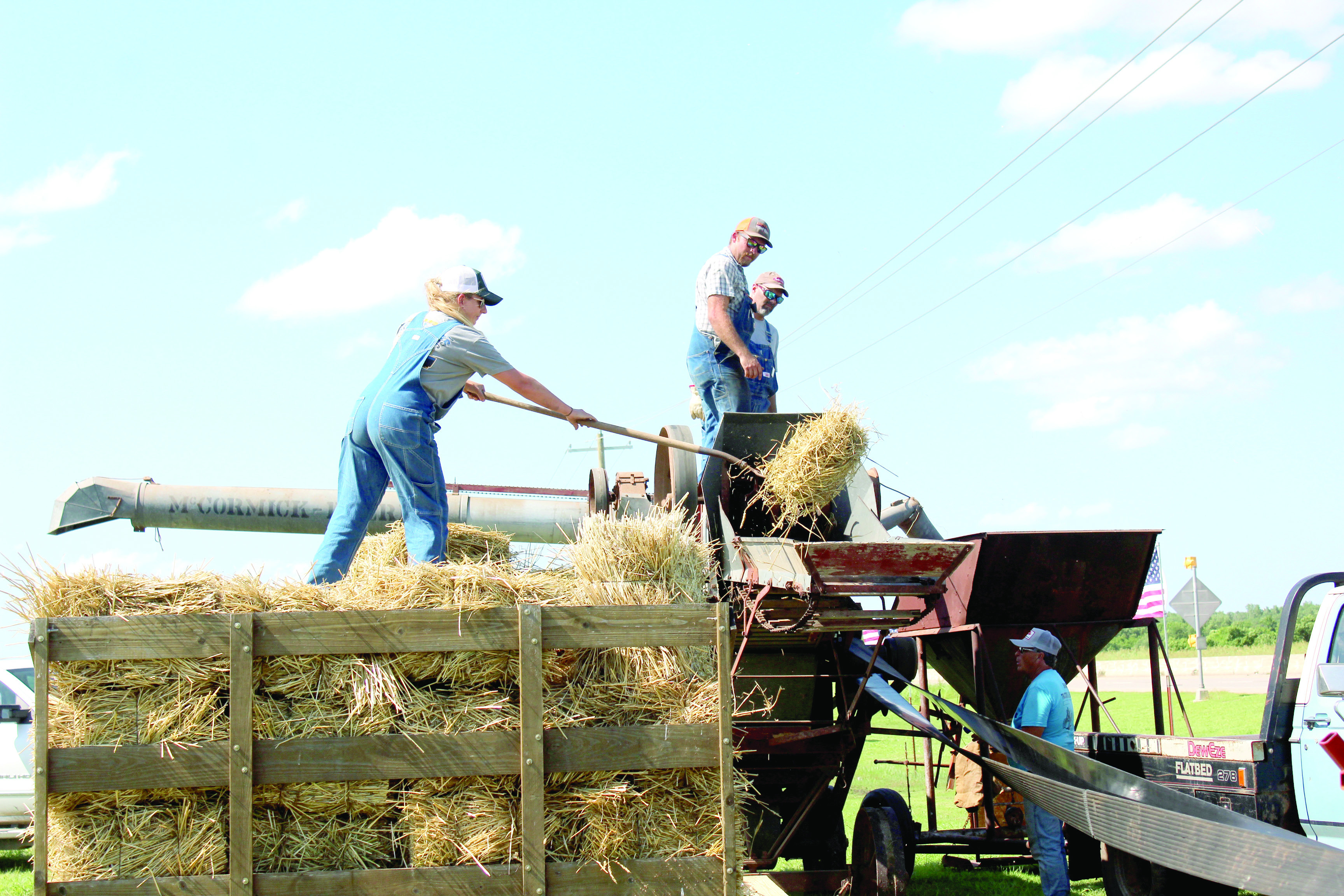 Shelby Smith feeds hay into a 1922 McCormick-Deering separator, as Dylan Smith and Ricky Hostetter oversee operations during the 26th Annual Farming Heritage Festival, held at Shawnee Feed Center on June 20-21. John Marlow said they had trouble finding wheat to separate this year due to wet conditions. The separator, made in Canada, was brought to the festival by the Silver City Antique Tractor Club in Tuttle. This year, the event doubled as the Early Day Gas Engine & Tractor Association National Show.