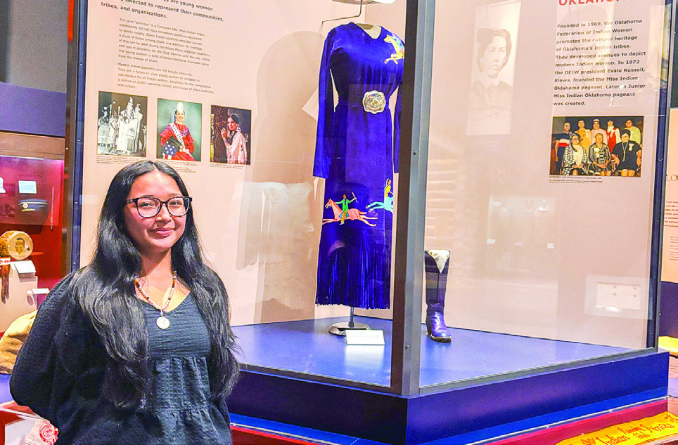 Seminole State College freshman Alivia Wapskineh, 2025 Miss Seminole Nation, stands in front of the Indian Princesses exhibit at the Oklahoma History Center. Photo Provided