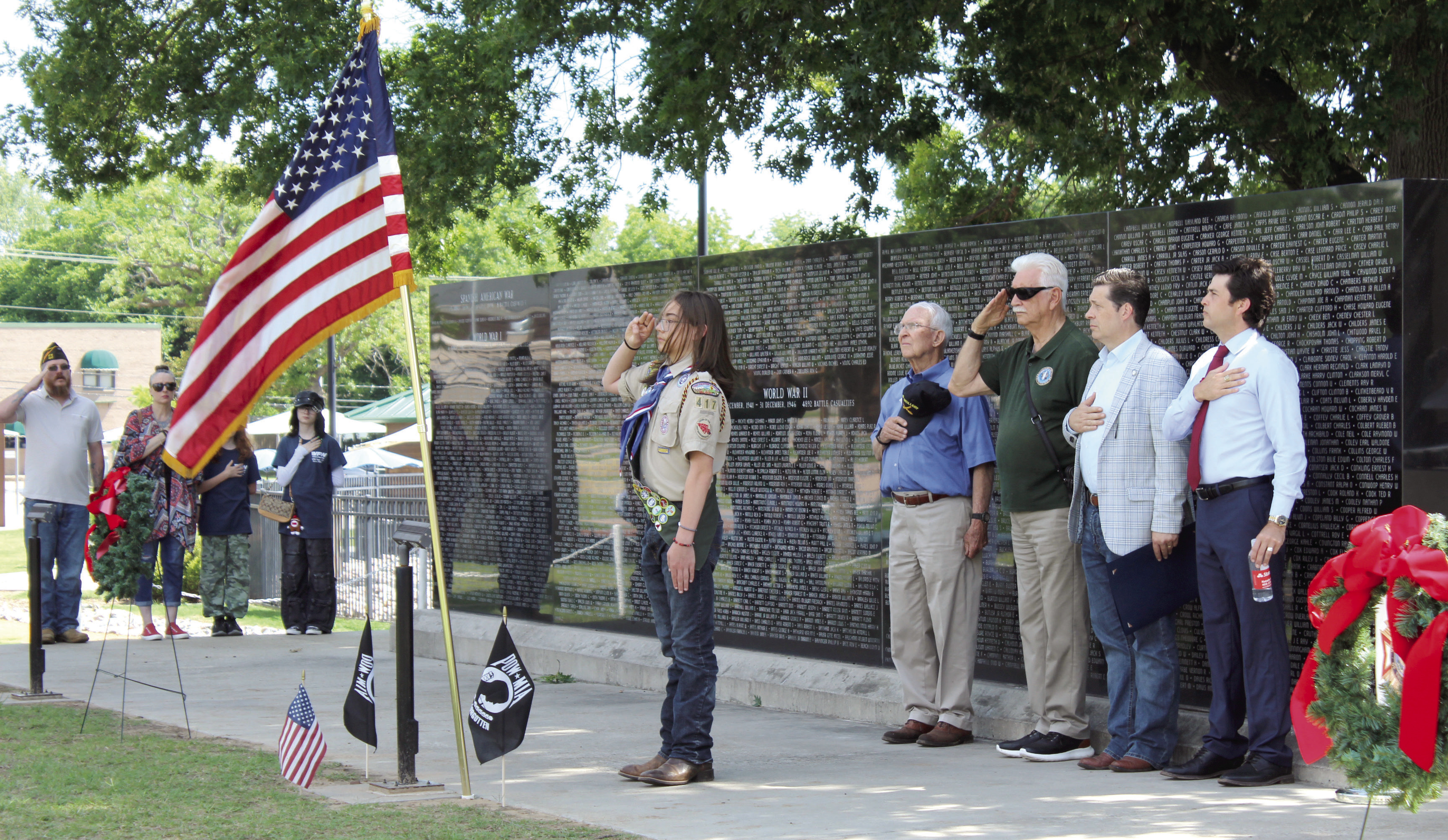 Troop 477 Eagle Scout Lucas Schafer, 16, salutes the U.S. fl ag after posting the colors, as Bill Ford, Jerry Shiles, State Senator Shane Jett and Former State Rep. Justin Wood and others do the same, during the Shawnee Memorial Day ceremony at Woodland Veterans Park on May 25. Jett and Wood spoke at the event. Natasha Dunagan, Countywide &amp; Sun