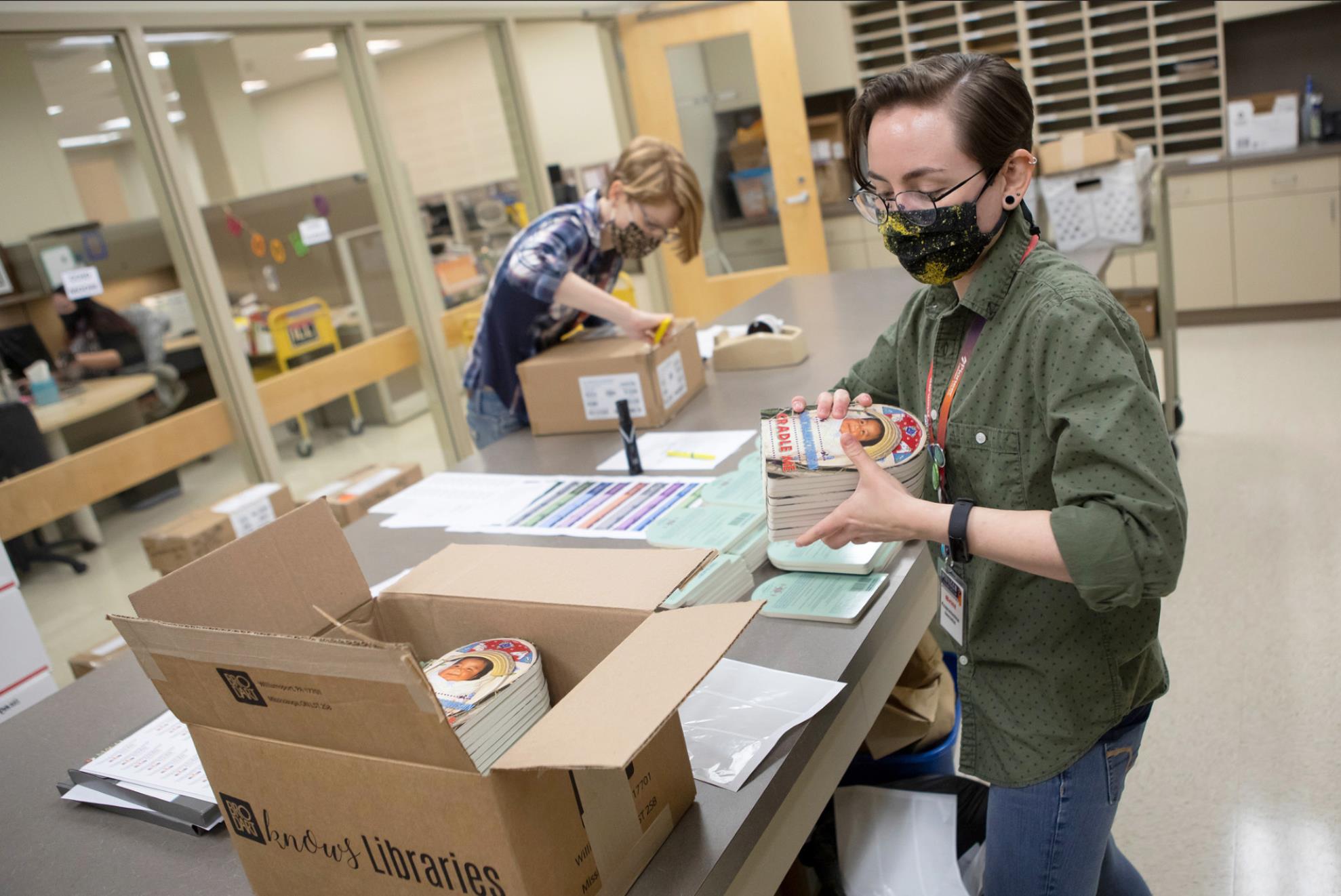Above, Tribal member Britt Muirhead prepares boxes of books at the Pioneer Library System in Norman, Friday, Sept. 24, 2021. This year Pioneer Library System Foundation is donating books to CPN WIC with photos of Indigenous babies and Ojibwe vocabulary. Photo provided by CPN