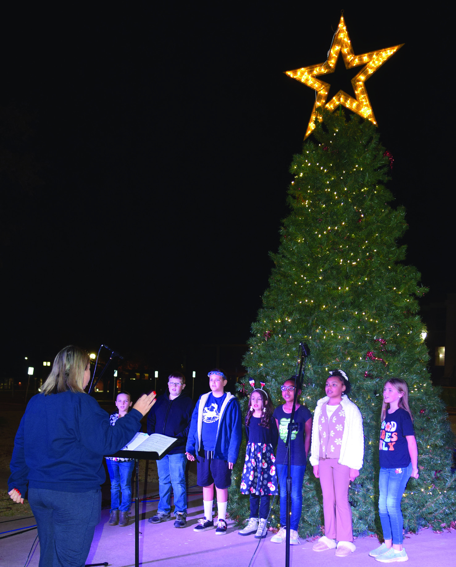 Horace Mann music teacher, Carrie Hathcock, directs carolers performing on the Oval. From left: Zoe Riley, Riyan Wade, Toby Osburn, Kassidee Smith, Andrinee Banks, Promise Spoon and Payton Charvat.