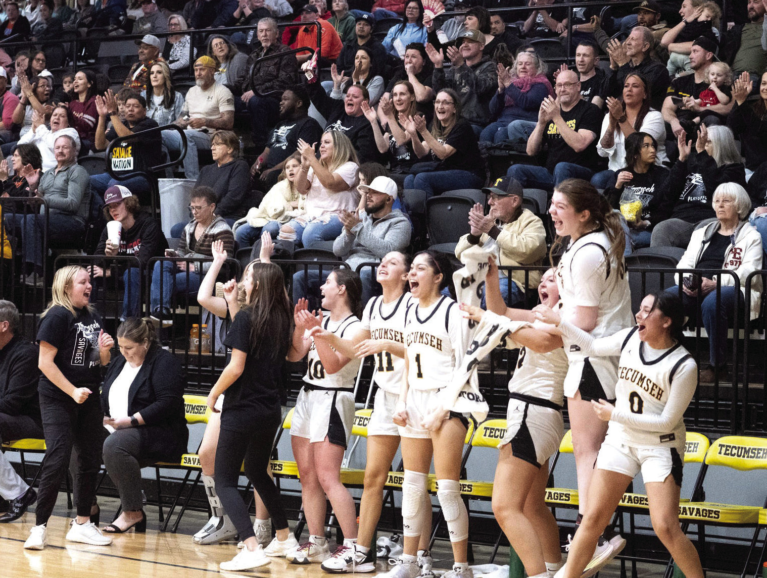 The Tecumseh Lady Savage starters cheer from the bench during the second half of the Class 4A District game with Crossings Christian on Feb. 17. They won the district championship, 79-26. Photo provided by Kenetta Lisenbee.