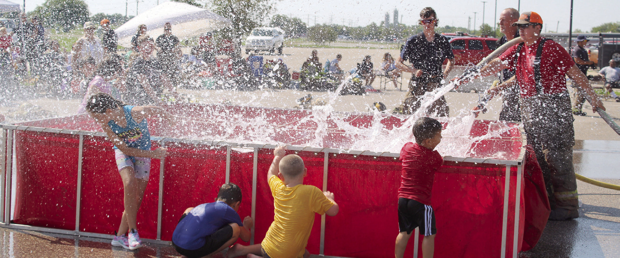 Bud Crawford, of Konawa, far right, and Steve Reese, of Asher, fill a tank and provide some water fun for kids attending the Firefighter Olympics at the Pottawatomie County Free Fair on Sept. 10. File photo