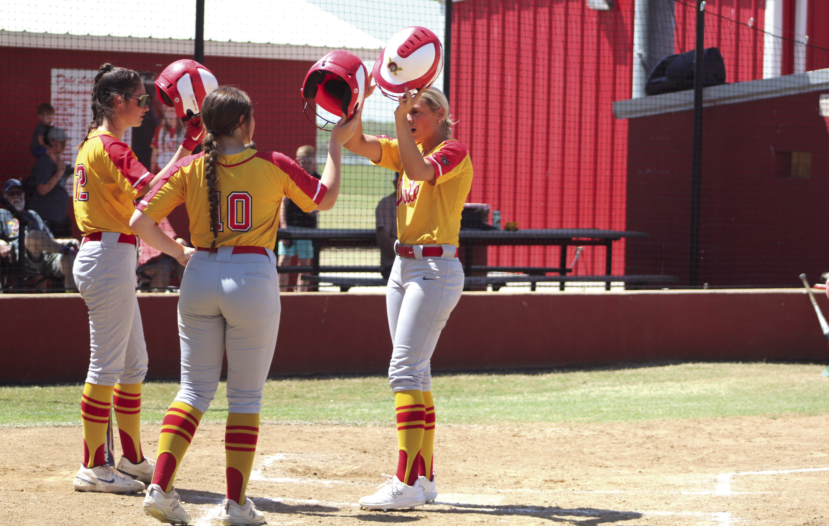 Dale’s Chayse Caram, far right, hits helmets with her teammates after hitting a home run in the fourth inning of the Dale Festival game with Silo on April 14. The Lady Pirates won that game, 12-7, and they won their two games on the previous day, as well. Dale beat Oktaha, 12-11, and Deer Creek, 13-1.