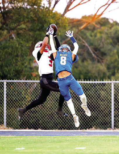 Bethel junior Garrison Reid (#8) and McLoud senior Sabir Perry grab for the ball during Bethel's first home game on Sept. 12. The Wildcats won, 58-32. Photo courtesy of Richelle Treece