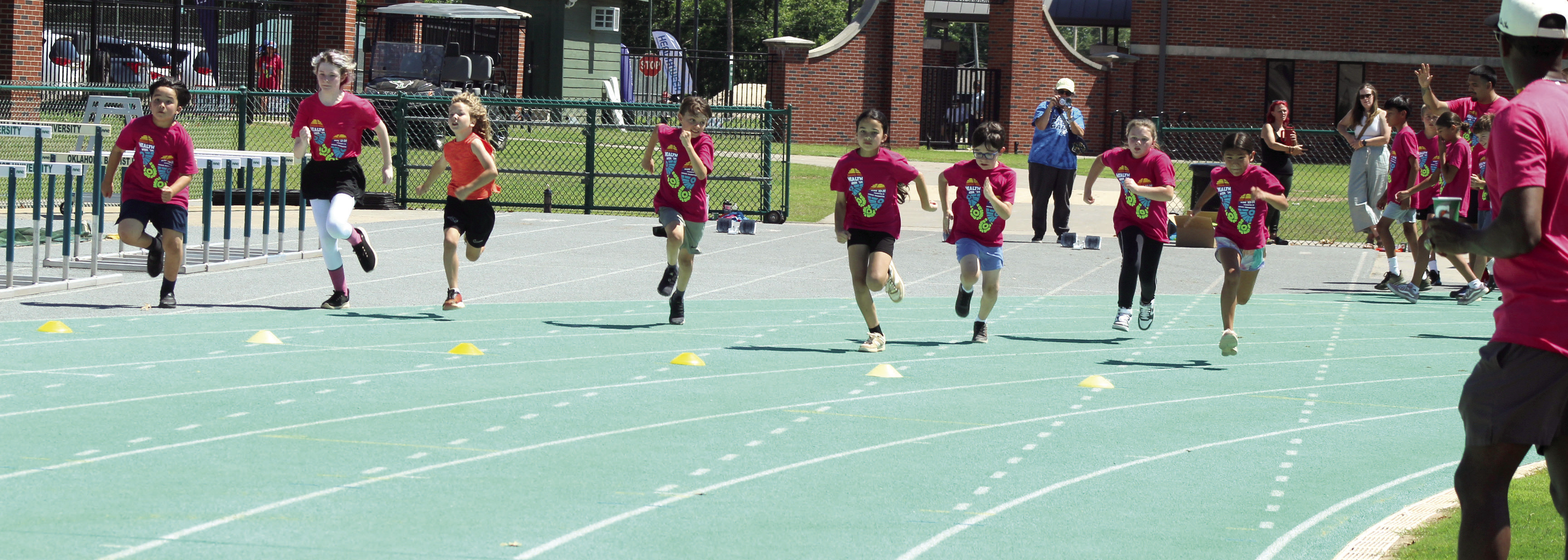 Students in first through sixth grade race during the Health Week Track Clinic, as former track star Charles Clark, far right, watches, at Oklahoma Baptist University on May 28. There were 48 students who participated in two sessions, said Macy Muirhead with Pottawatomie Go (POGO). Photos by Natasha Dunagan, Countywide & Sun