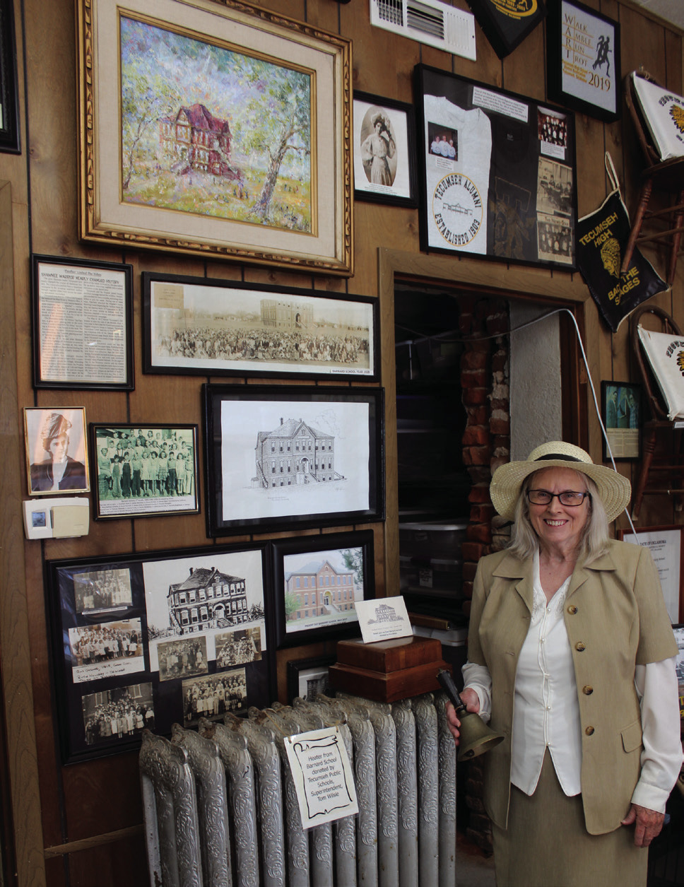 Tecumseh Historical Society member Arthenia Haney, dressed as Kate Barnard, rings a school bell amidst the display about Barnard and the elementary school named after her on April 11. Haney will be playing Barnard again for the Tecumseh Museum's 30th Anniversary Open House on April 19 from 10 am to 2 pm. Prints of the Tecumseh Centennial painting by Barbara Hertz will also be in a silent auction that day. Natasha Dunagan, Countywide & Sun