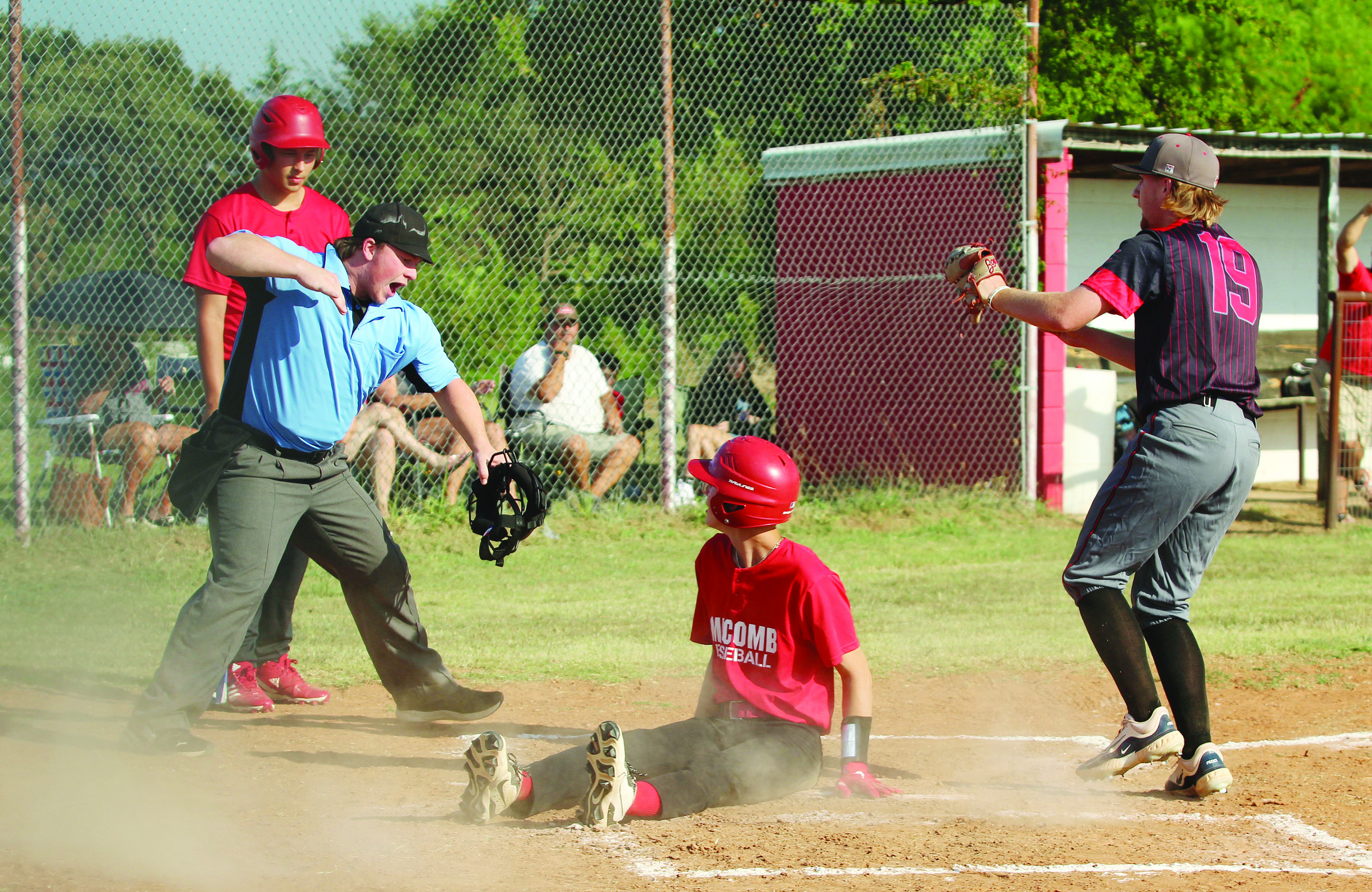Macomb senior Connor Hutchinson slides in to steal home but is declared out by the umpire after Earlsboro senior, pitcher Jon Wilkins (#19), ran up for the tag during the baseball game at Macomb on Aug. 14. The Earlsboro Wildcats won, 18-0. 