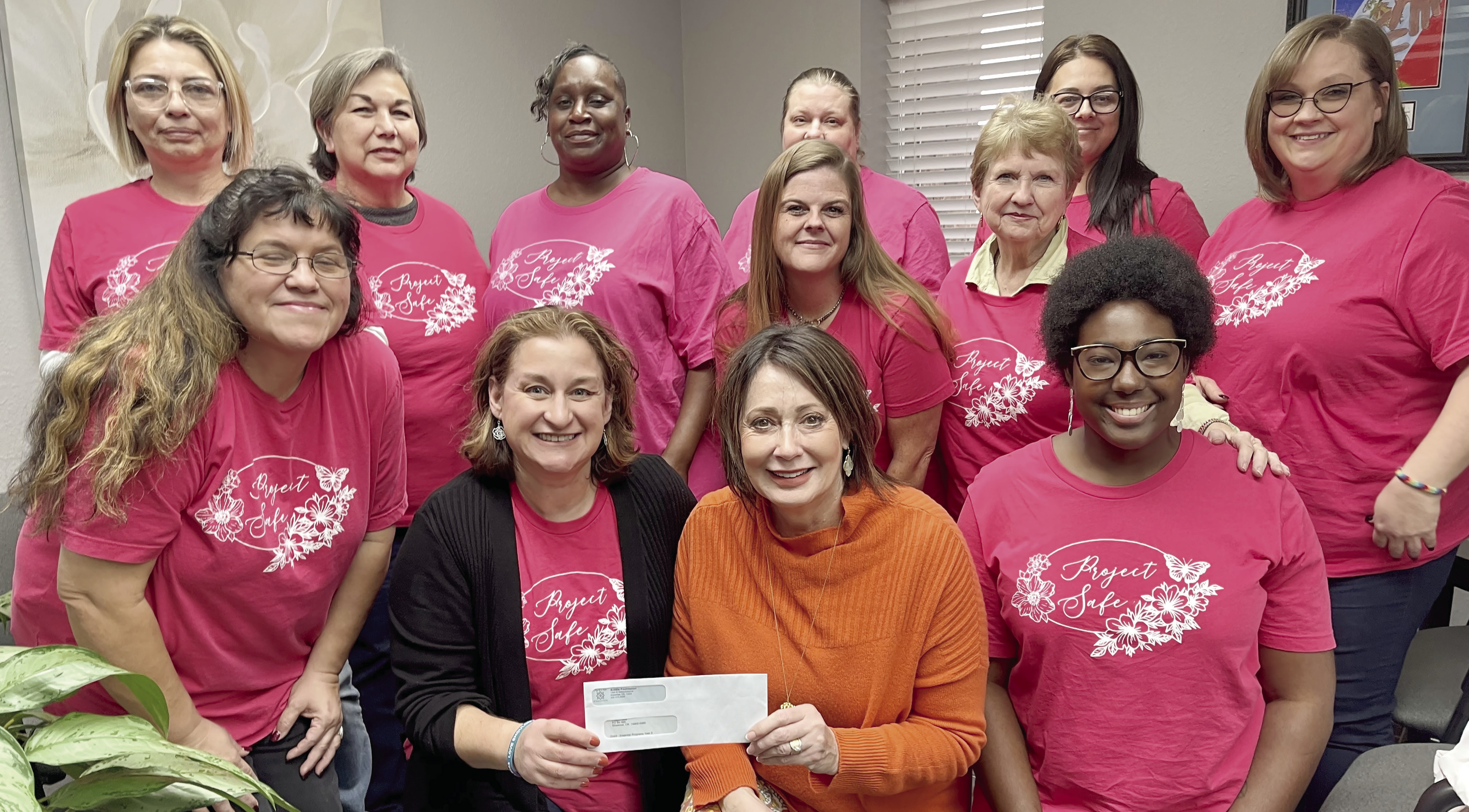 Surrounded by Project: SAFE staff, Renee Clemmons, Project: SAFE Executive Director, is presented a grant check by Kathy Laster, President &amp; CEO of the Avedis Foundation. Photo provided