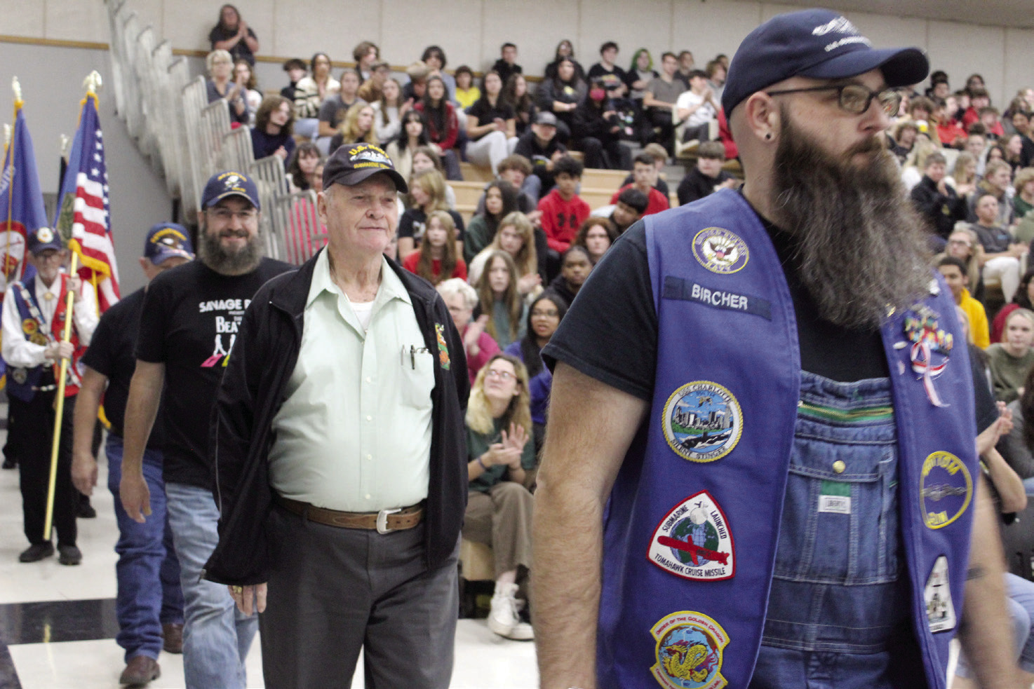 Navy veterans, from left, Philip Wolke, Charles Spillers and Becket Bircher walk in the Veterans Parade at the Tecumseh High School Veterans Day Assembly on Nov. 10. There were about 30 veterans who walked in the parade and were applauded as they lined up in front of the audience. There were also pictures of around 40 veterans, who were related to students and staff, shown in a slide show throughout the event. Countywide & Sun/Natasha Dunagan