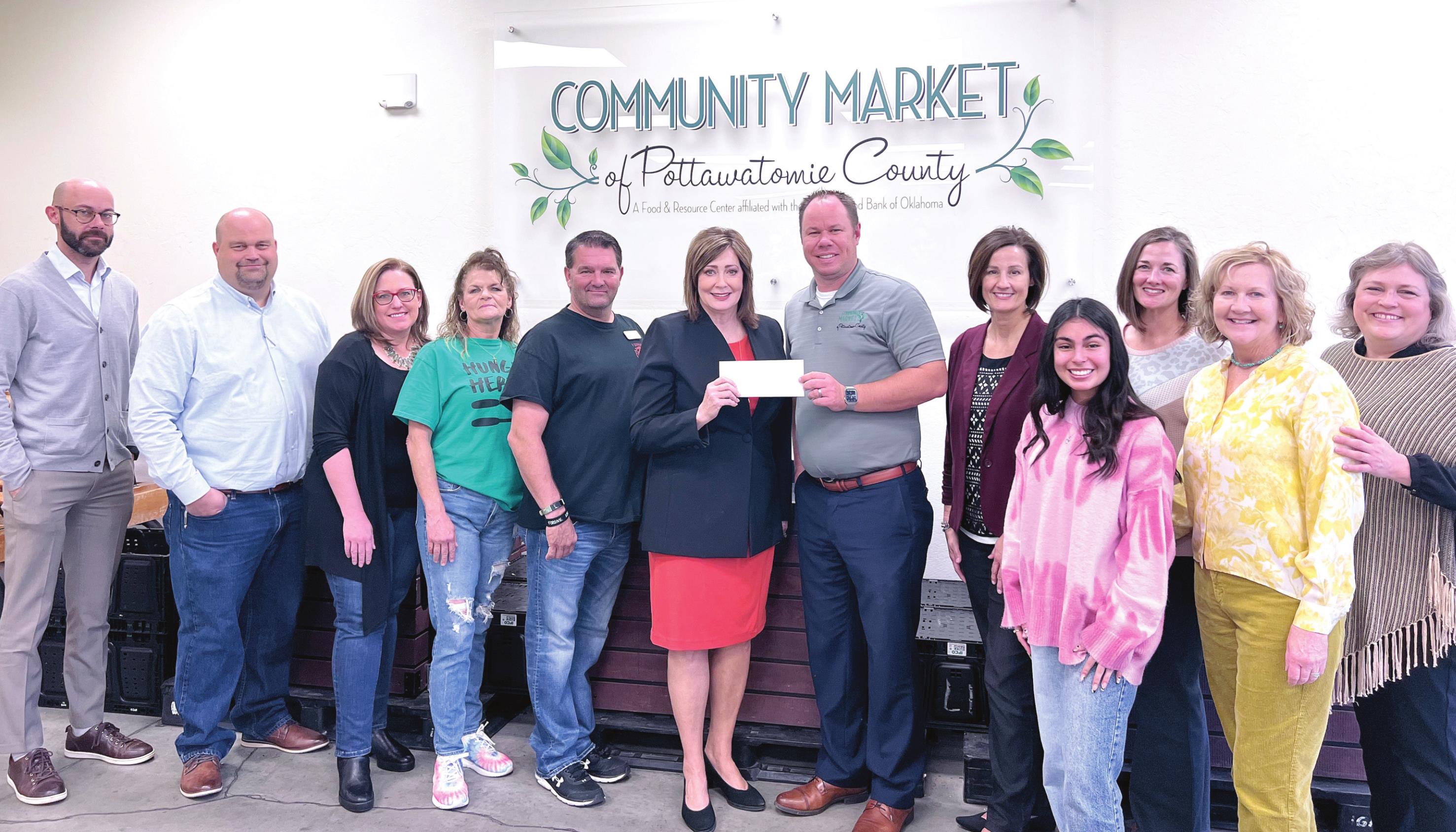 Kathy Laster, Ph. D. President &amp; CEO Avedis Foundation (center) presents a check to Daniel Matthews, Executive Director CMPC. Angi Mohr, Avedis Board Member &amp; President SSM Health St. Anthony Hospital Shawnee (pictured to the right of Matthews) is joined by Board and Staff from Community Market of Pottawatomie County and Staff from the Avedis Foundation. Photo provided