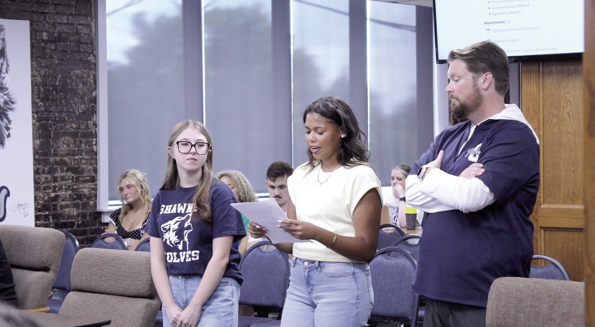 Shawnee Student Council member, senior Michale Young, speaks to the Shawnee Public Schools Board of Education about plans for one homecoming for the school year, which will include a dance and a parade, during the Aug. 10 meeting, as fellow senior and Stuco member, Kadence Jenkins, and Stuco Sponsor Ryan Boren look on. Natasha Dunagan, Countywide &amp; Sun