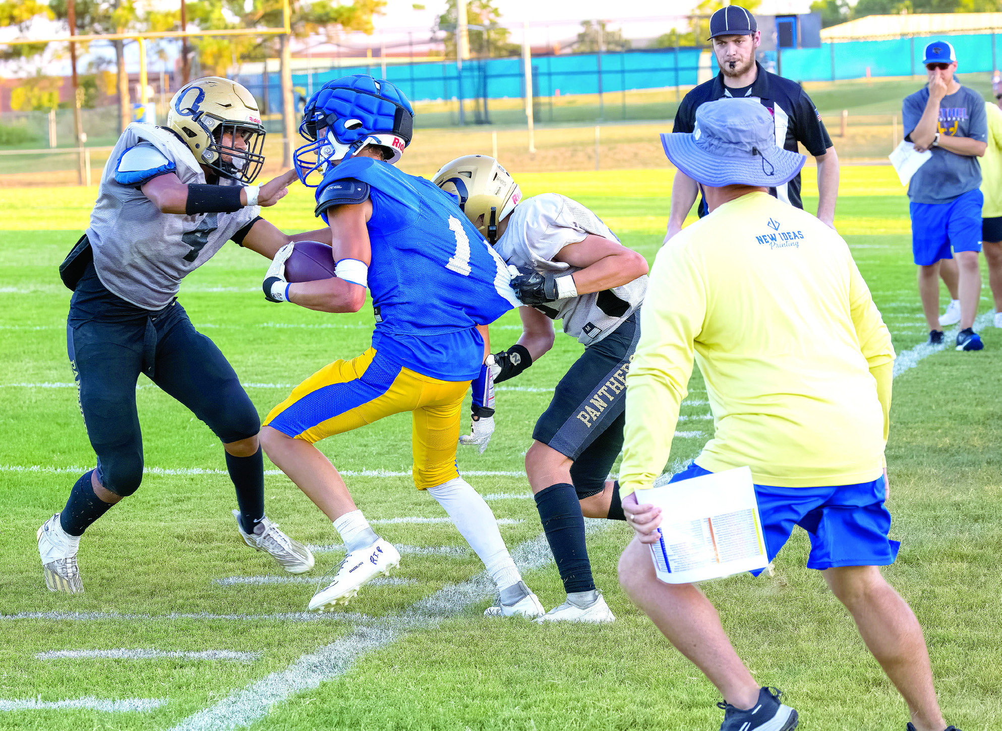 Bethel’s Reagan Curry tries to run the ball around two Okemah players during a scrimmage on Aug. 25, as the referree blows his whistle. Bethel also played Woodland that day. Photo provided by Richelle Treece.