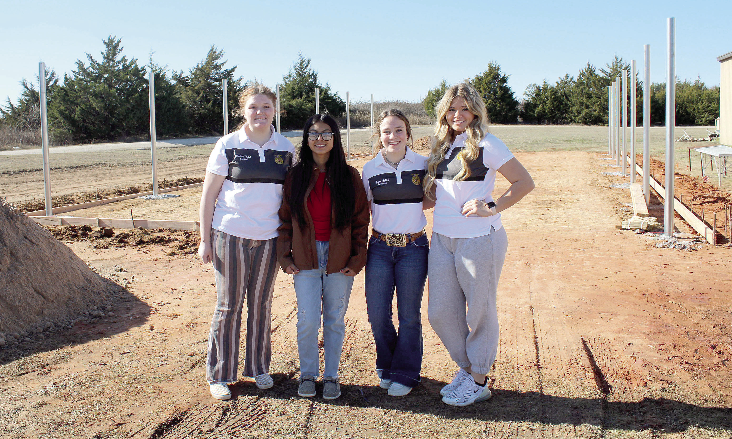 McLoud FFA Sentinel Madison Bickel, Historian Mayrin Perez, Treasurer Emma Bellah and Chaplain Austyn Wood stand in front of where the new McLoud FFA greenhouse is being constructed. The greenhouse was approved by the school board in July and was paid for with ESSER III funds. Countywide &amp; Sun/Natasha Dunagan