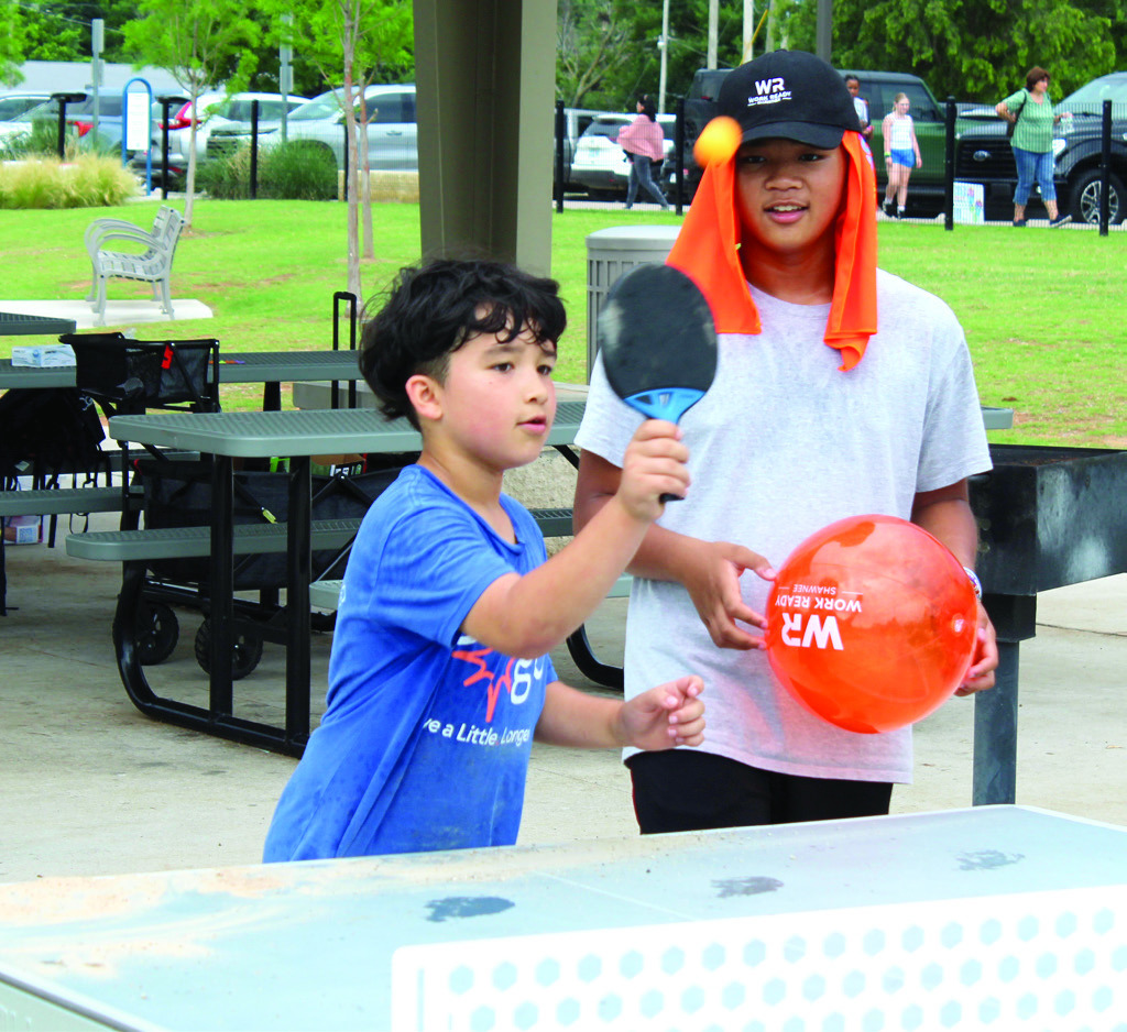 Troy Russ, 7, of Shawnee, plays ping pong, as Russell Tampus, 13, watches during the Health Week 'Fun Day at KidSpace Park' on the morning of May 29. Giant checkers, corn hole, pickleball, 40-yard dash, ninja course and the Roll and Stroll Walk were also available. A rain storm cut the activities short around 11 am. The event returned that evening from 5-8 pm. Natasha Dunagan, Countywide &amp; Sun