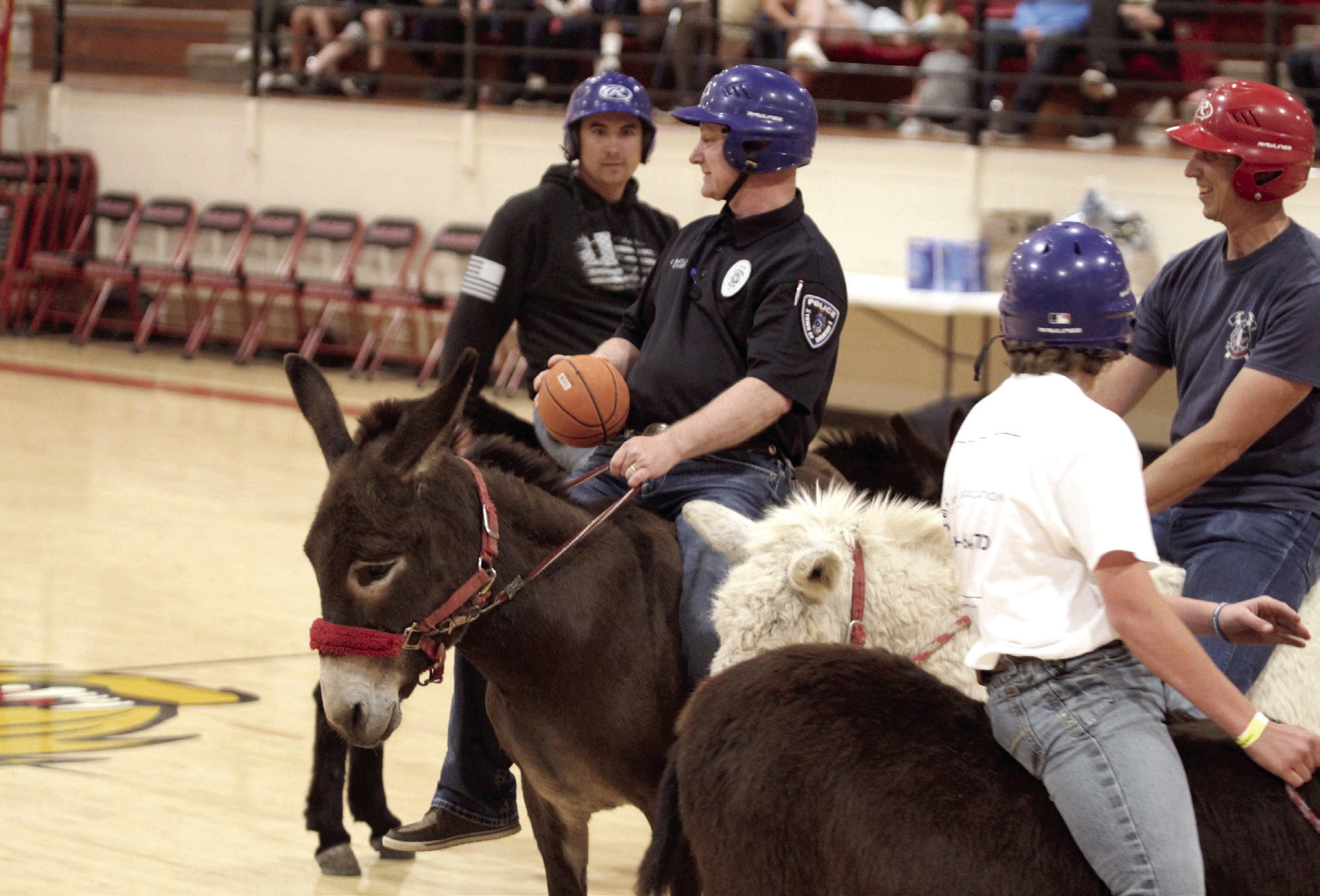 Earlsboro Police Chief Christopher Bayless, with the Hoof Patrol team, looks to pass during the Third Annual Earlsboro Donkey Basketball fundraiser on April 4 at the EHS Gym. Shown, from left, are Anthony Glasgow, Bayless, Bayless's son, Easton Barnes, and firefighter Caleb Inman. See full cutline below.