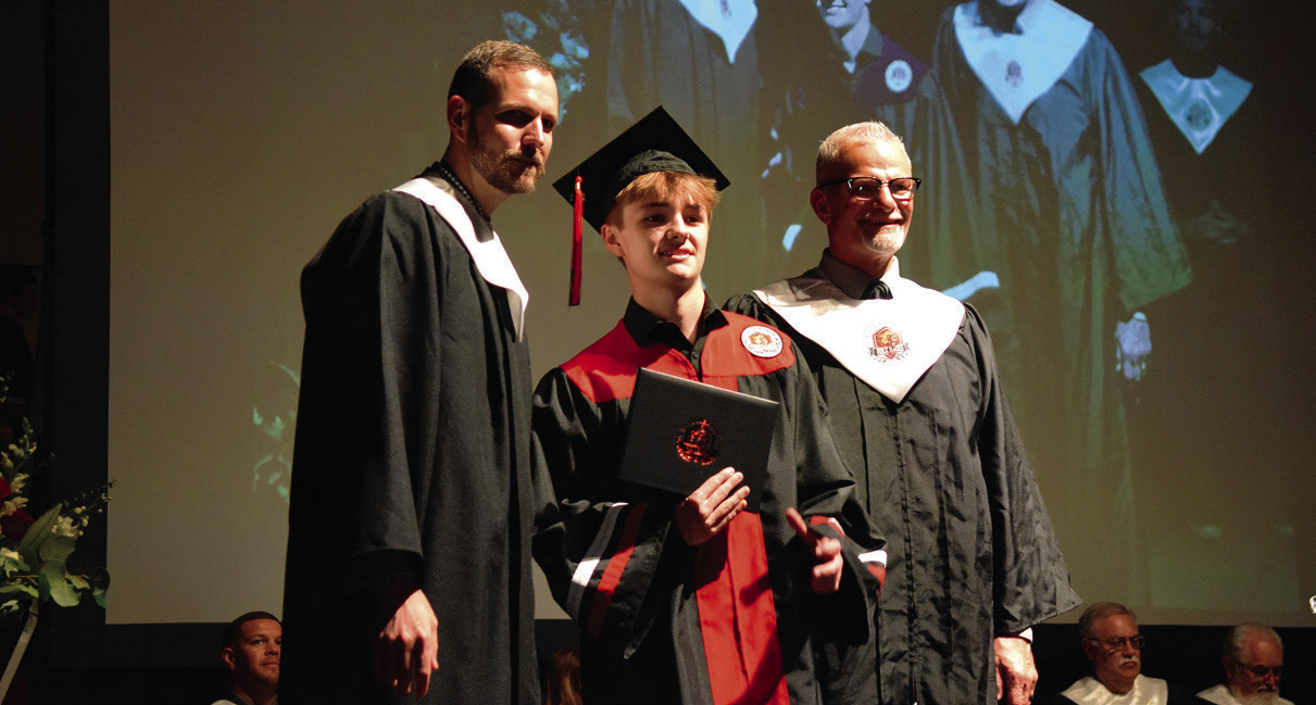 Bronson Armitage receives his diploma from Principals Justin MacDonald and Chad Brooking. Photos by Julie Talton, Countywide & Sun