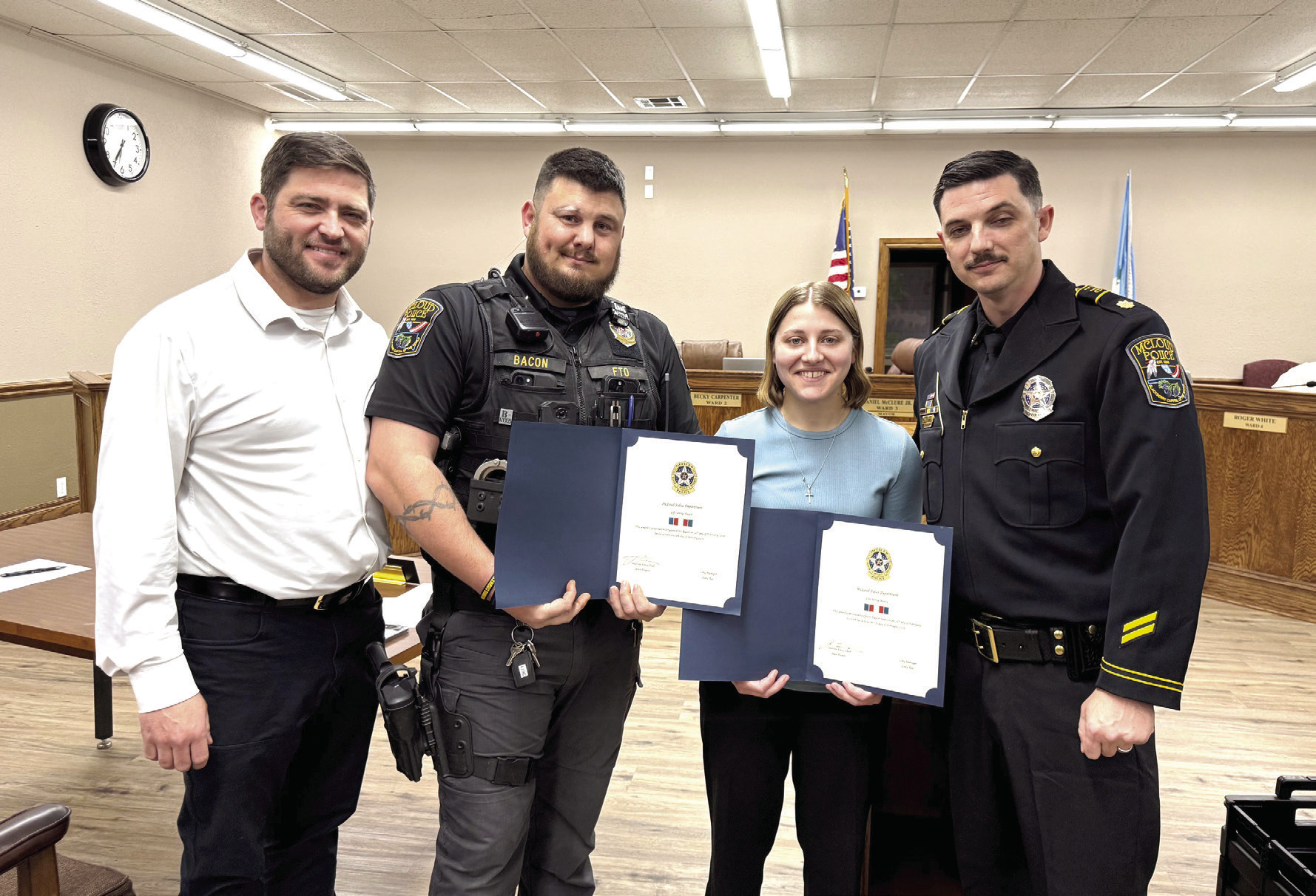 McLoud Mayor Daniel McClure (left) and Major Alan Pinette (right) pose with Sgt. Chris Bacon and Officer Taylor Swanson. Bacon and Swanson were both given commendations for providing life saving treatment to citizens last month, on separate occasions. Julie Talton, Countywide &amp; Sun