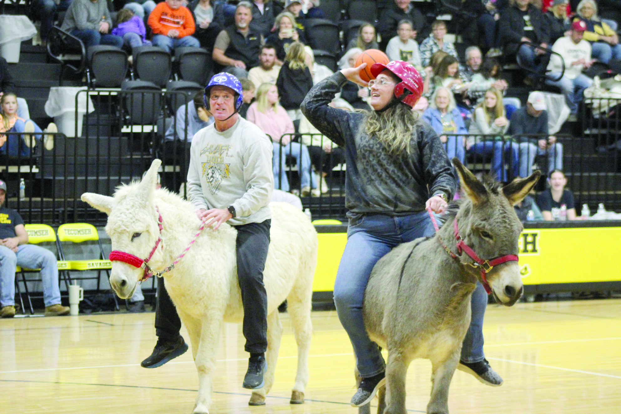 Tecumseh Middle School Softball Coach Kayla Kirby shoots for two, as Tecumseh High School Assistant Principal Rodney Buss watches, during the Tecumseh Tip In Club Donkey Basketball fundraiser on Oct. 29. Countywide & Sun/Natasha Dunagan