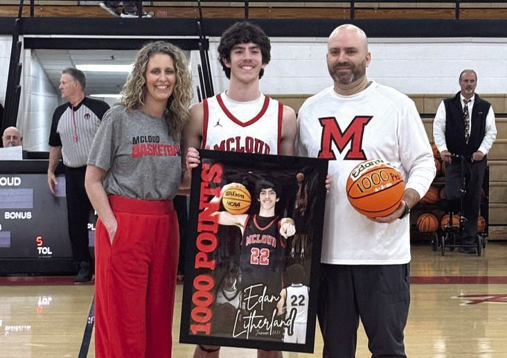 McLoud junior Edan Litherland poses with his parents, Stephanie and Eric Litherland, who are presenting him with his 1,000 Points banner and game ball on Feb. 6. The younger E. Litherland reached 1,001 high school career points during the Feb. 3 game at Tecumseh, where he contributed 34 points. The elder E. Litherland is McLoud's Head Boys Basketball Coach and Athletic Director and also celebrated his 200th win as a coach on Feb. 6. Natasha Dunagan, Countywide &amp; Sun