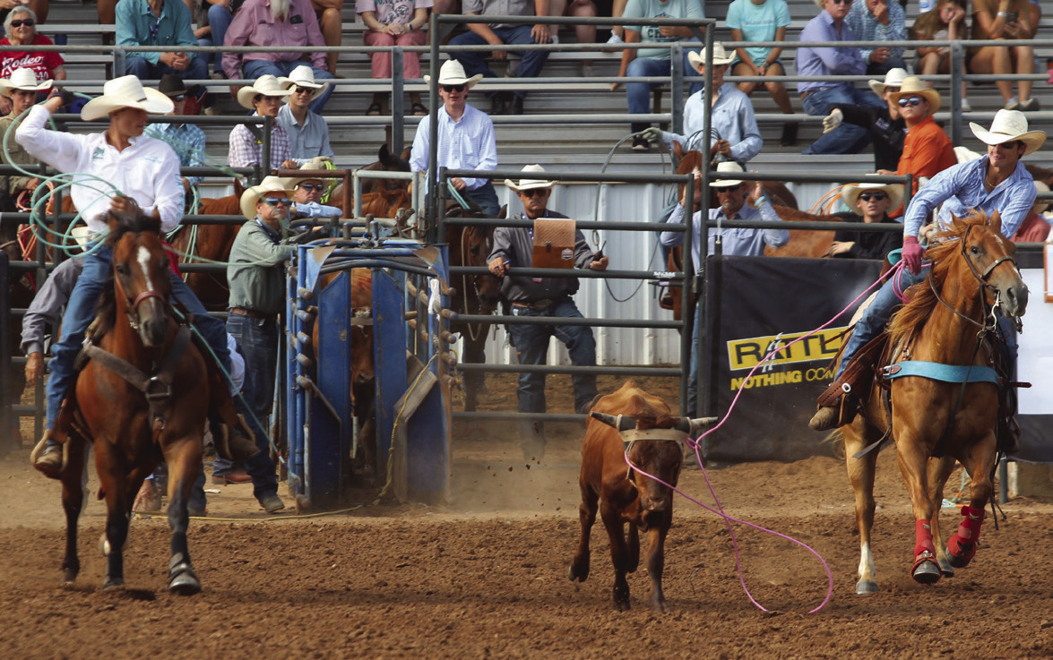 Kolton Yeager of Shawnee, right, loops his lasso around the steer's horns as Tyler Fish of Harrah prepares to catch the back feet in Team Roping on the morning of July 7. See more IFYR photos in the B section. Natasha Dunagan, Countywide &amp; Sun
