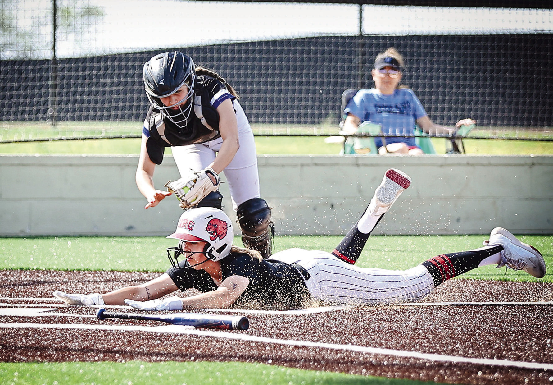 NRC's Sophie Morris slides past the Little Axe catcher for the score. North Rock Creek won both games on their new turf field, March 30, against Little Axe and Lexington. Photos Courtesy of Gowin Photography.