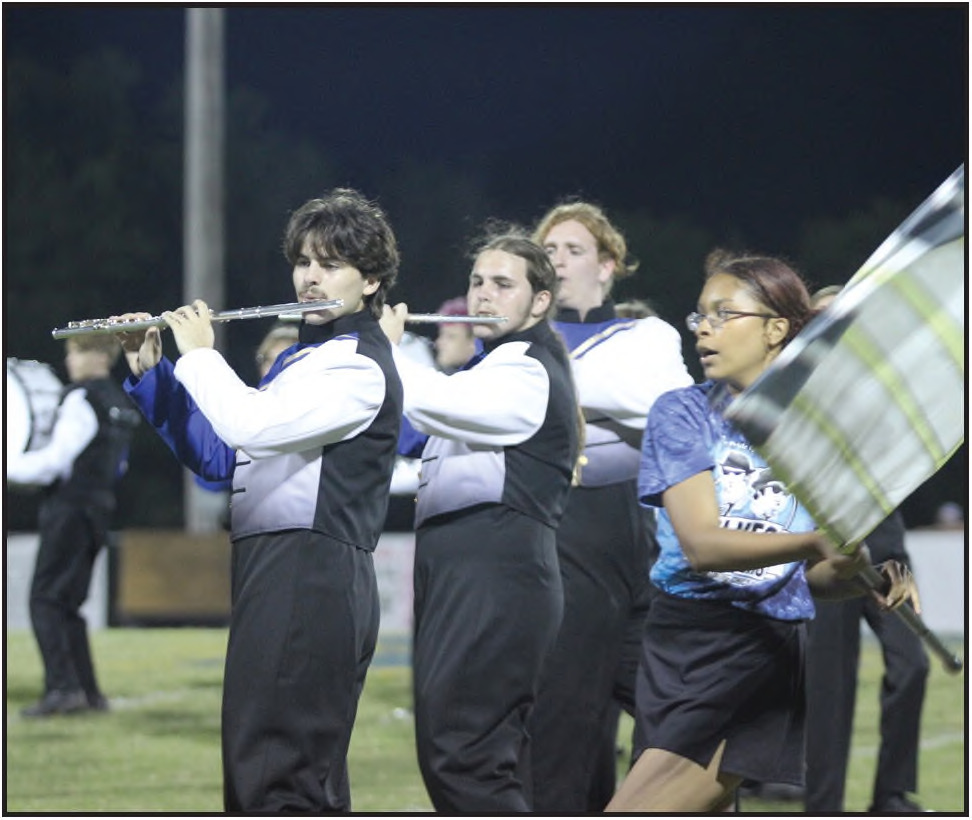 Pride of Bethel band members Cayden Ricker, Nathan Ricker, and Elijah Robertson perform music from the Blues Brothers, as color guard member Patience Steli dances around them with her flag, during the Sept. 6 football game halftime. File photo