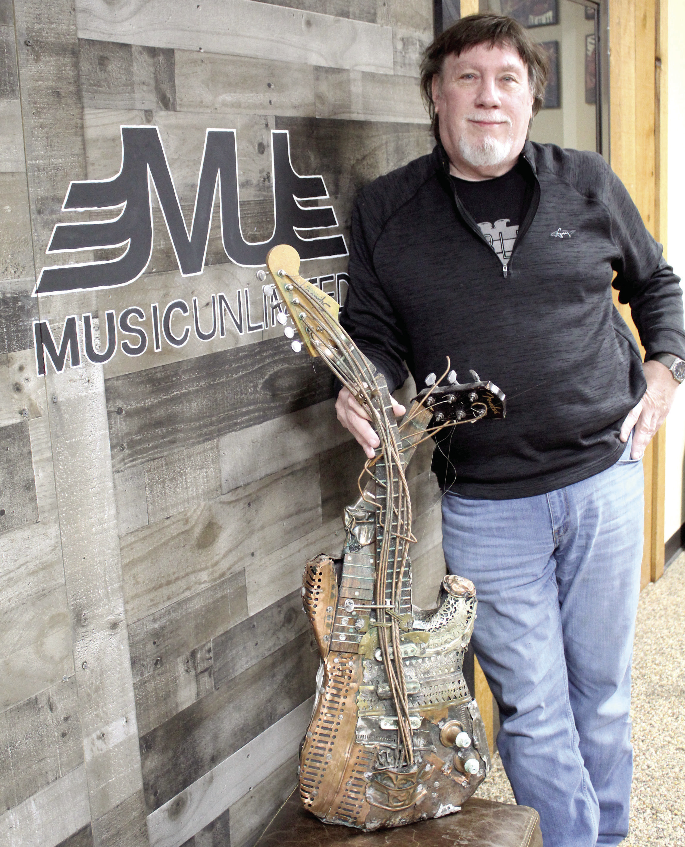 Music Unlimited Owner Jeff Hawkins poses with his favorite guitar artpiece at the store in Jan. 2025. Hawkins passed away in March 2025, but his wife, Joni Hawkins, is keeping his dream alive and the business running. Singer-Songwriter Night, which was started by Jeff and his friend Kevin Hall, resumed last September. File Photo
