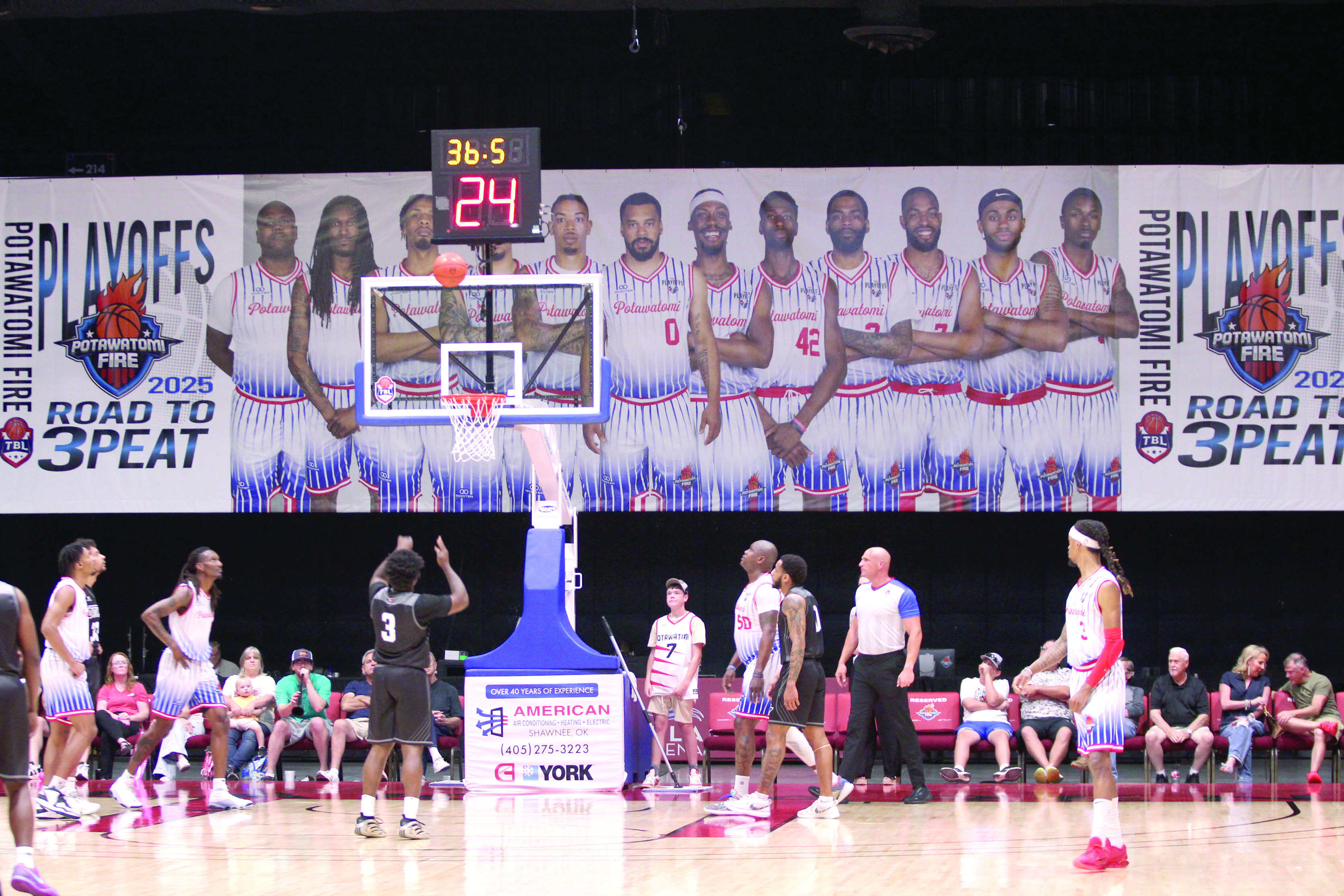An Enid player shoots free-throws with a giant Potawatomi Fire 'Road to 3Peat' banner as a backdrop during the first quarter of the Central Division Finals Game 2. The Fire beat the Enid Outlaws, 157-89, in this game and in the first game at Enid, 122-98. They move on to the Midwest Conference Finals today (June 5) and June 7, both days at 7 pm at FireLake Arena, according to potawatomifire.com. 