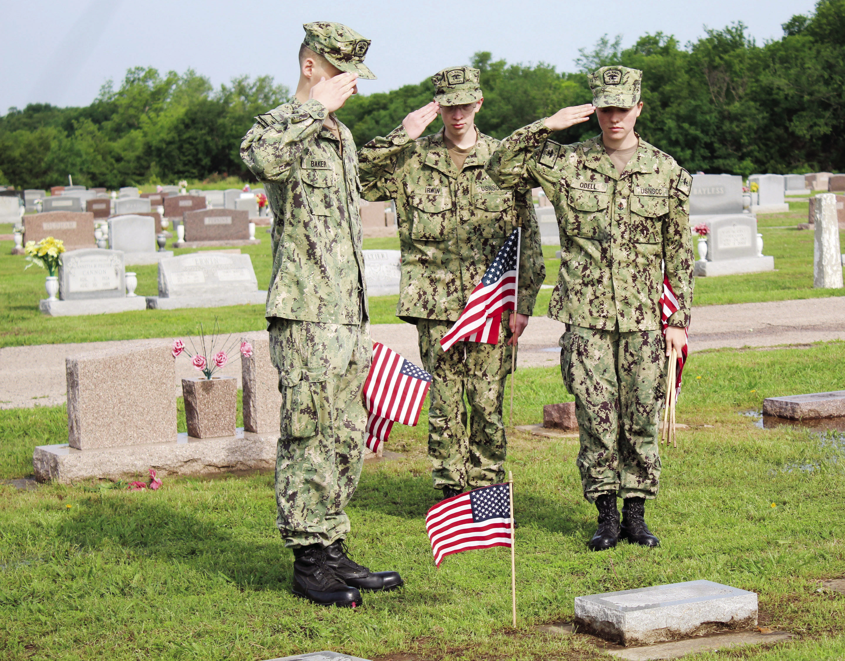 Petty Officer Third Class Lukasz Baker, Seaman Recruit Kenneth Irwin, and Chief Petty Officer Anna O’Dell salute a flag placed on a veteran’s grave at Tecumseh Cemetery on May 20. There are approximately 1,200 veterans’ graves at the cemetery, which were decorated in preparation for Memorial Day by the U.S. Naval Sea Cadets and Training Ship Oklahoma members, according to Sea Cadets Regional Director Donna Snodgrass. Countywide &amp; Sun/Natasha Dunagan