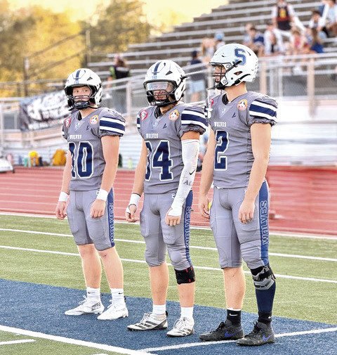 Nolan Ward, Jayce Bullock, and Riley Storie wait on the Wolves’ sideline sporting Jim Thorpe jerseys, provided by the Sac &amp; Fox Nation.