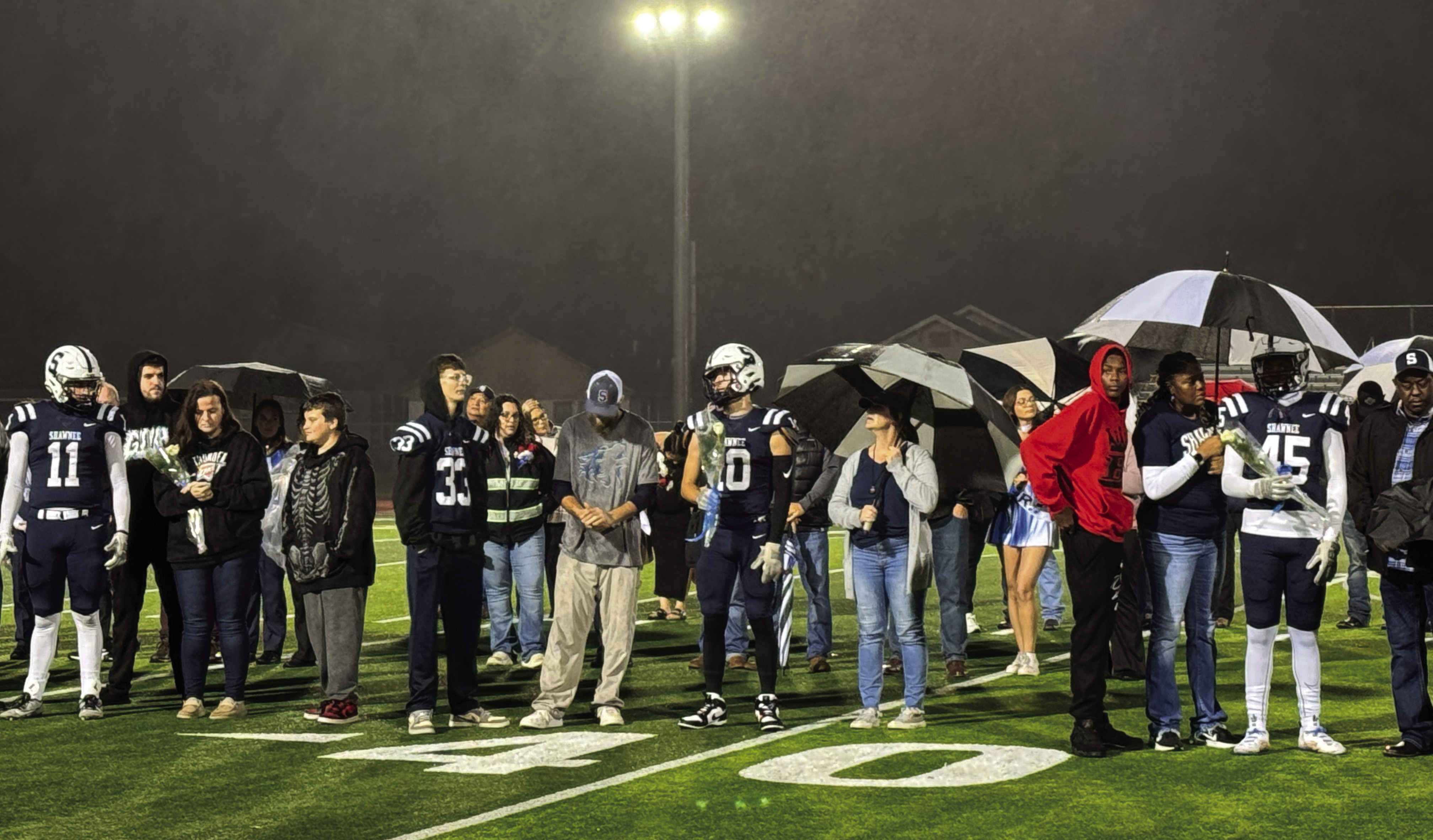 Football players and their families participate in the Shawnee High School Fall Senior Night - a very rainy night - on Nov. 8. Band, cheer, choir and cross country seniors were also included. Photo provided by Amanda Johnson