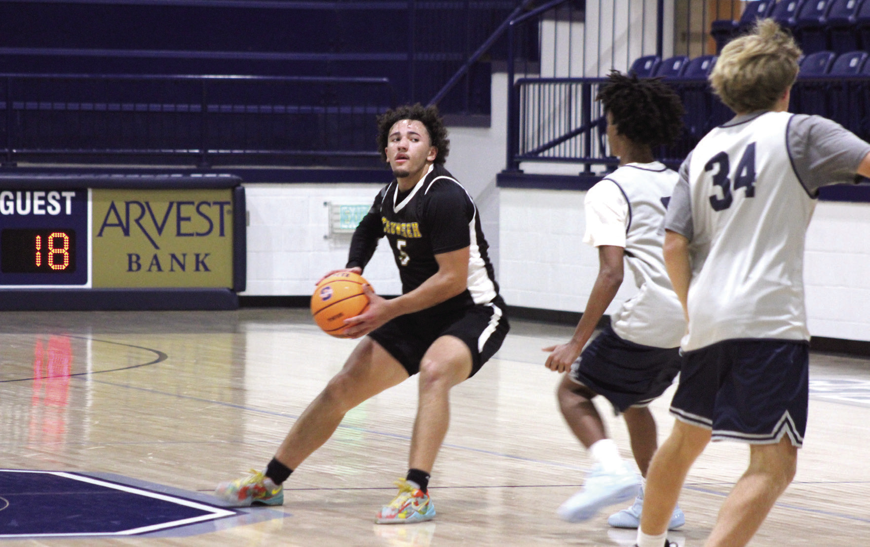 Tecumseh senior Aveon Stokes plans his next move past Shawnee juniors Levi Baughman and Jack Timmons during the basketball scrimmage at Shawnee on Nov. 6.