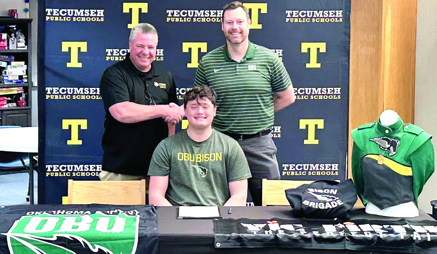Tecumseh's David Lawrence signed with Oklahoma Baptist University Bison Brigade Band. Shown shaking hands are Tecumseh Band Director John Outon, left, and OBU Band Director Dr. Brian Stackhouse. Photo provided by THS