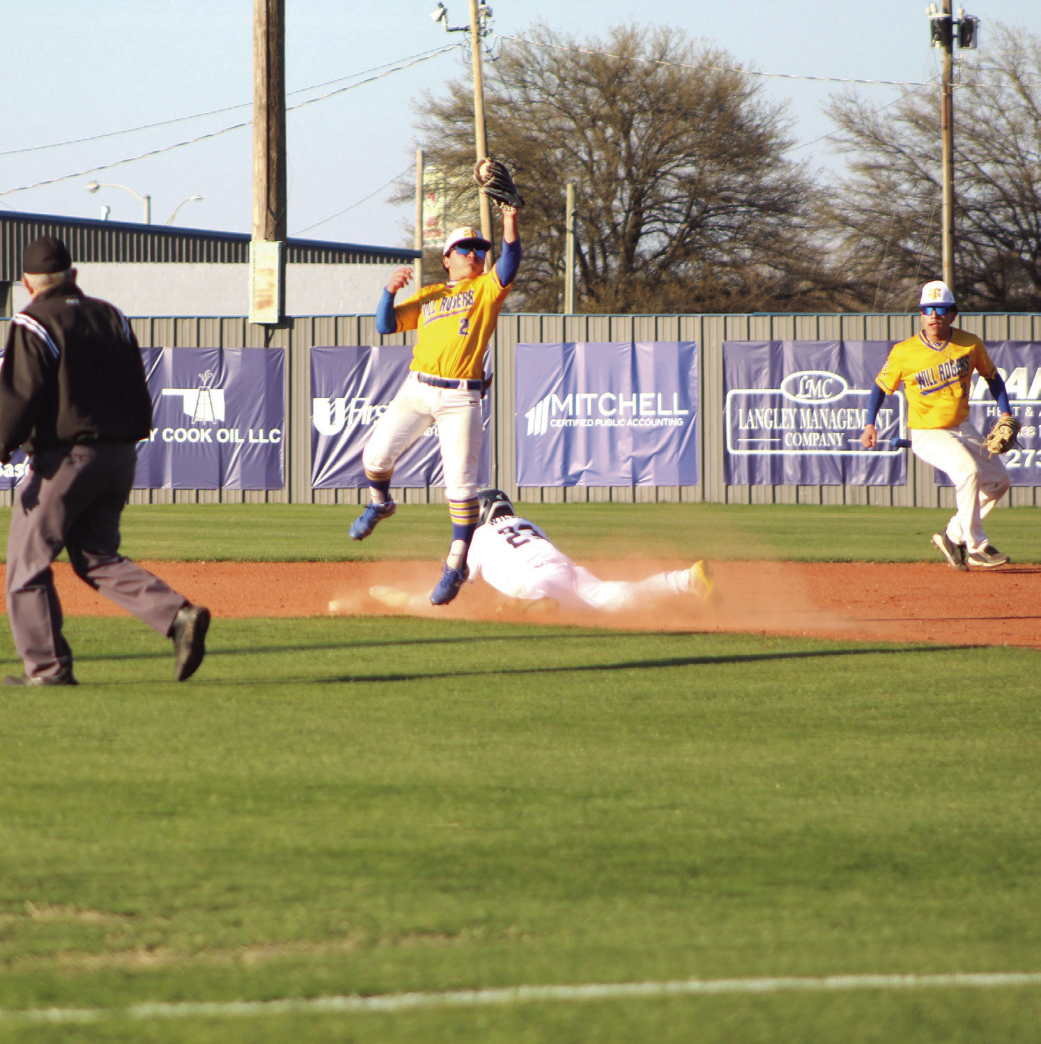 Shawnee's Zane Wilson steals second base as a Will Rogers players jumps for the ball in the first inning of the home game on March 28. The Wolves won, 10-0. Countywide & Sun/Natasha Dunagan