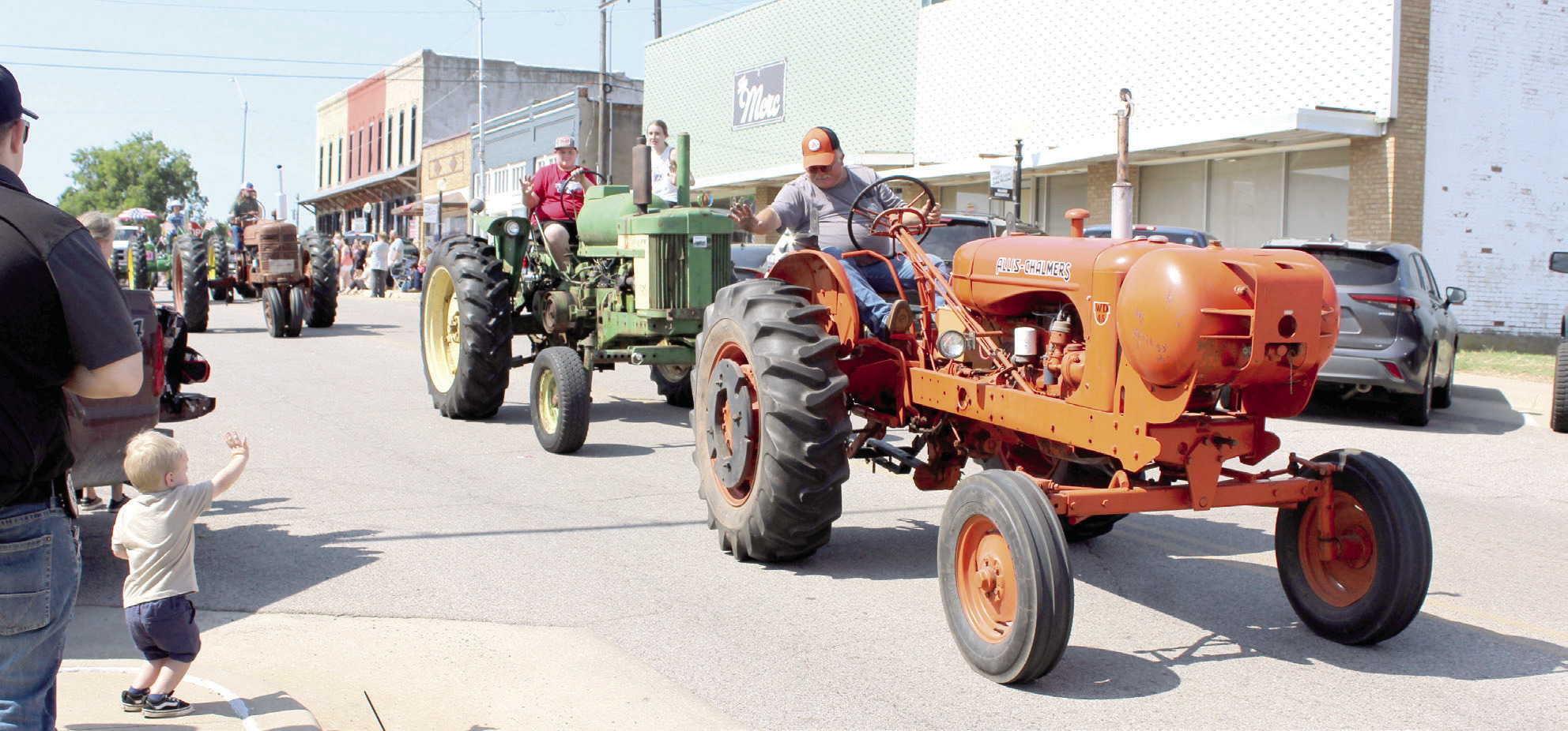 A member of the Shawnee Tractor Club waves to a young boy during the McLoud Blackberry Festival Parade on July 13, 2024. There were 75 entries in the parade. File photo