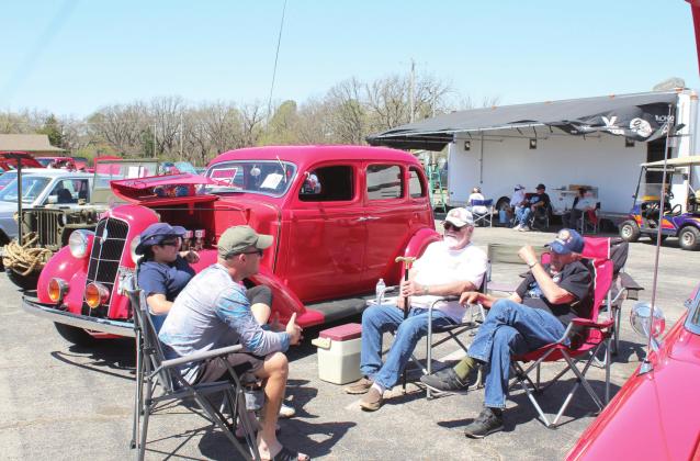 Bethel residents Steven Dodson, Karoline Dodson, Gary Goetz and Les Arnold have a conversation next to a 1935 Plymouth PJ in the Modified Pre-1970 Class at the Sixth Annual Bethel Band Boosters Car Show on April 9 at Bethel High School. Countywide &amp;amp; Sun/Natasha Dunagan