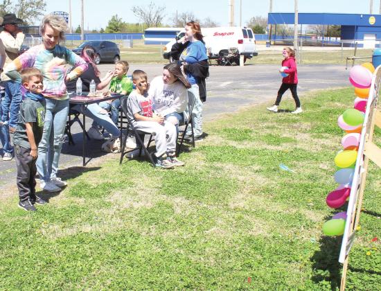 Ryker Benard, 5, of Shawnee, tries his luck at the balloon toss, as his grandmother Angie Roberts watches during the Sixth Annual Bethel Band Boosters Car Show on April 9. Face painting was also available, and those shown are Bethel band member Destiny Swearingen painting Colby Watts, 7, of Tecumseh, and Art Club member Kimber O’Rorke painting Liam Benard, 8.