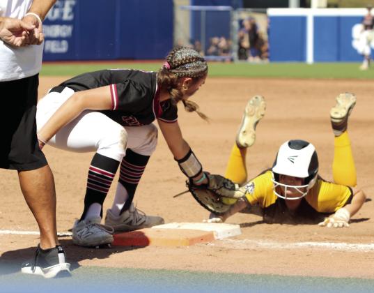 Tecumseh junior Josie Walker dives back safely to first base in the fourth inning.