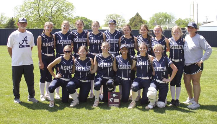 The Asher Lady Indians pose with Head Coach Tari Dubler, far right, and Assistant Coach Scott Dubler, far left, as well as their Class B District Slow Pitch Champion trophy on April 17. They beat Paden in a double header, 12-0 and 26-0, to take districts. On April 24, they played in regionals at Caney and lost, 6-10, but they won with Pittsburg, 9-5. Photo provided.