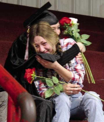 Kyra Looman gives a rose and a hug to her sister Halle Looman.