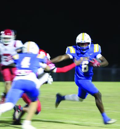 Bethel senior Ezra Powis dodges the Okmulgee defense as he carries the ball for a first down and 10 during the first quarter of the Oct. 31 homecoming game. This was one play before Powis made a touchdown.