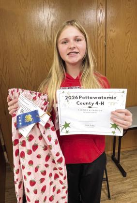 Addison Bristow holds her first place certificate alongside her strawberry patterned ribbon skirt. Photo provided by CPN