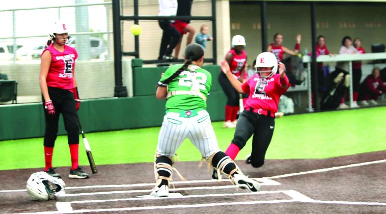 Earlsboro freshman Izzie Linzi slides to steal home, then moves out of the way so her teammate (#22) could also cross home plate. Shown, far left, waiting to finish batting, is freshman Jacklyn Satawake in the Macomb Fast Pitch Tournament game against Mill Creek at FireLake Ball Fields on Aug. 29. That day, the Lady Wildcats won with Mill Creek, 7-2, and with LeFlore, 6-5 in Extra Innings. On Aug. 30, they beat Macomb, 9-0, and lost to Cameron, 3-6, to become the tournament runners-up. By Natasha Dunagan