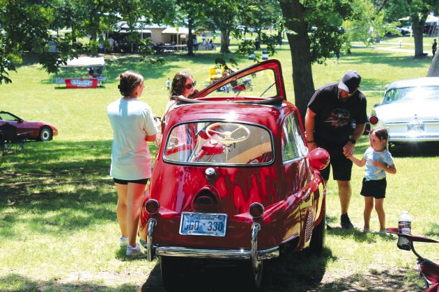 Abby Thompson, 12; Sarah Thompson; Ken Thompson; and Cora Thompson, 4, all of Tecumseh, look over a 1958 BMW Isetta 300, owned by Philip Farmer for the last 25 years. The Isetta won “Most Unusual” in the 36th Annual Knights Auto Club Car Show, held at Boy Scout Park on June 24. The event attracted more than 200 vehicles. Countywide &amp;amp; Sun/Natasha Dunagan