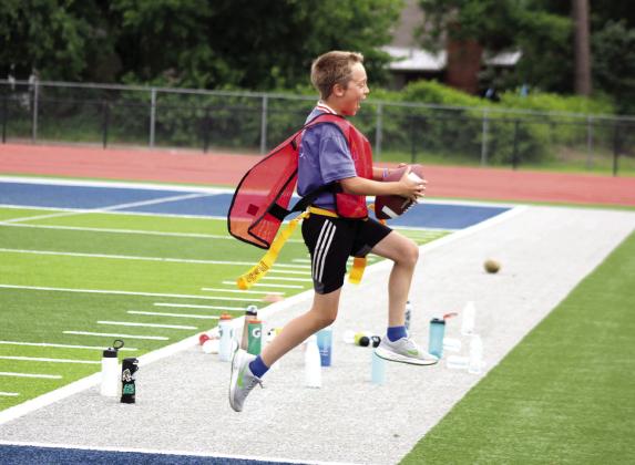 Collin Beck takes a flying leap as he makes a flag football touchdown during the Shamiel Gary Football Clinic. Natasha Dunagan, Countywide &amp;amp; Sun