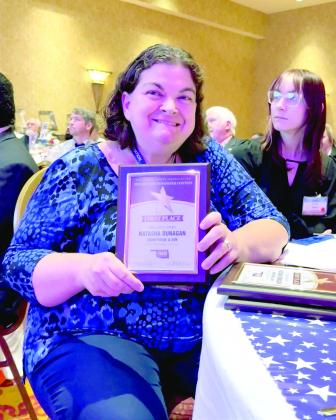 Natasha Dunagan poses for a quick photo with one of her first place awards. She took first in Education Story, News Story, and Business Story and third in Feature Story.